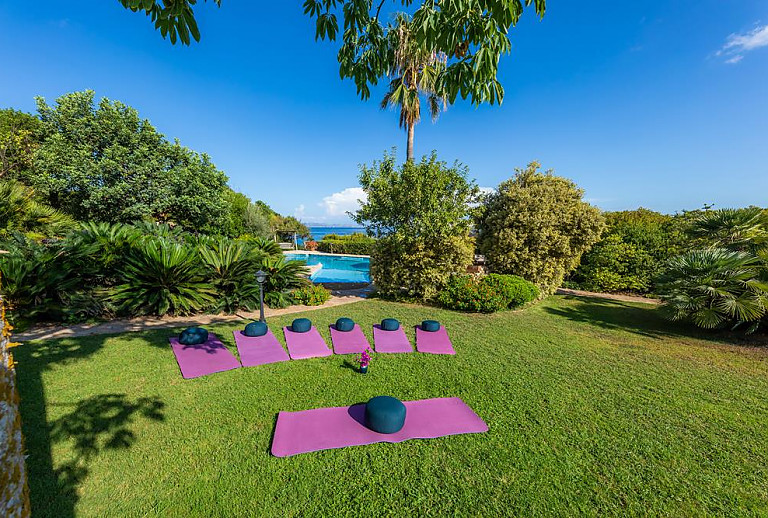 Yogamatten im Schatten der Bäume auf dem Rasen