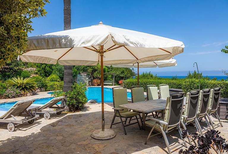 Gartentisch mit Stühlen und Blick auf das Meer