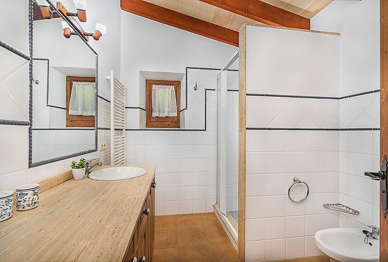 Badezimmer mit Dusche Waschbecken und Spiegel