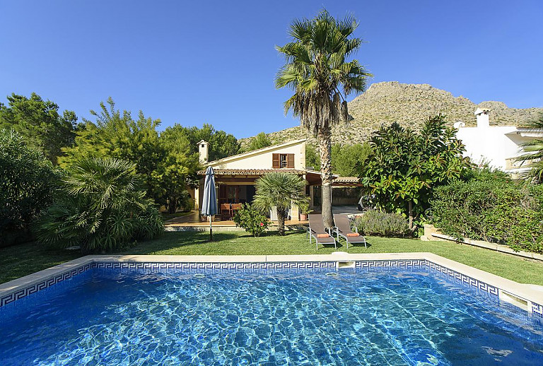 Poolbereich vor der Finca im Garten mit Rasen und Bäumen