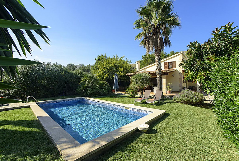 Pool vor der Finca im Garten mit Rasen und Bäumen