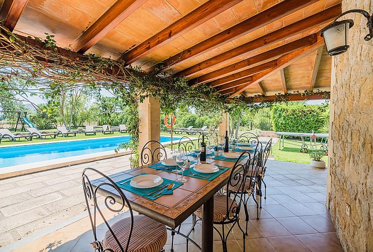 Terrasse mit Vordach und Gartenmöbeln