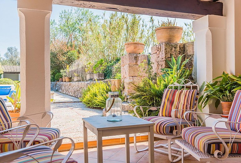 Überdachte Terrasse mit Essbereich und Poolblick