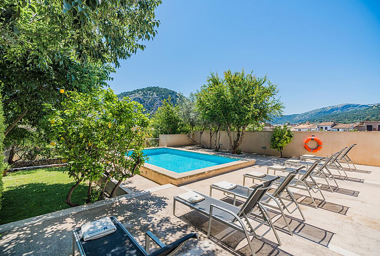 Poolbereich vor dem Ferienhaus mit Sonnenliegen