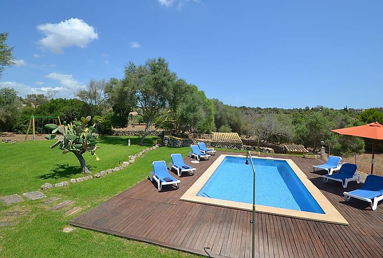 Blick auf den Außenbereich der Finca mit Pool und Sonnenliegen