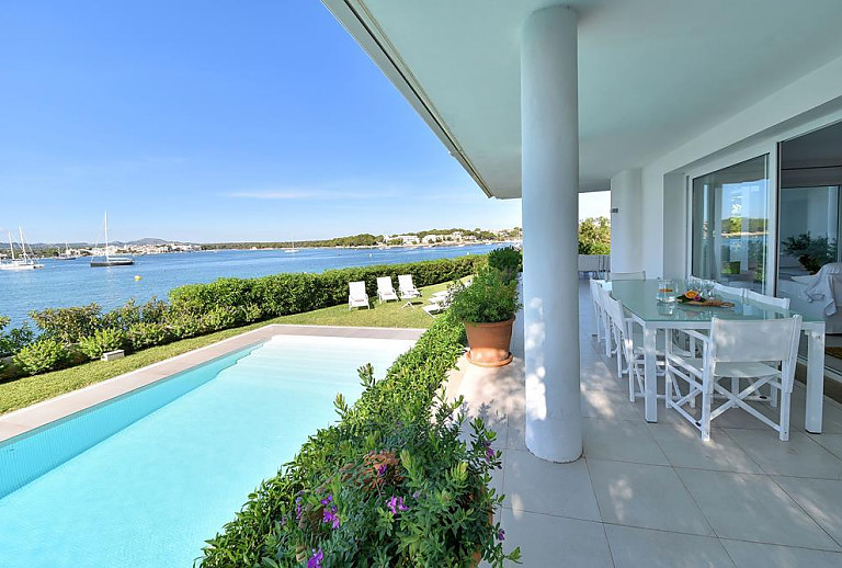 Terrasse mit Sitzmöbeln und Poolblick