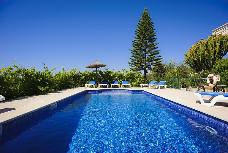 Pool mit Sonnenliegen vor dem Ferienhaus