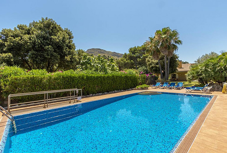 Pool mit Sonnenliegen vor dem Ferienhaus