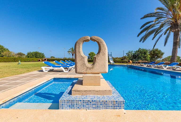 Pool mit Sonnenliegen vor dem Ferienhaus