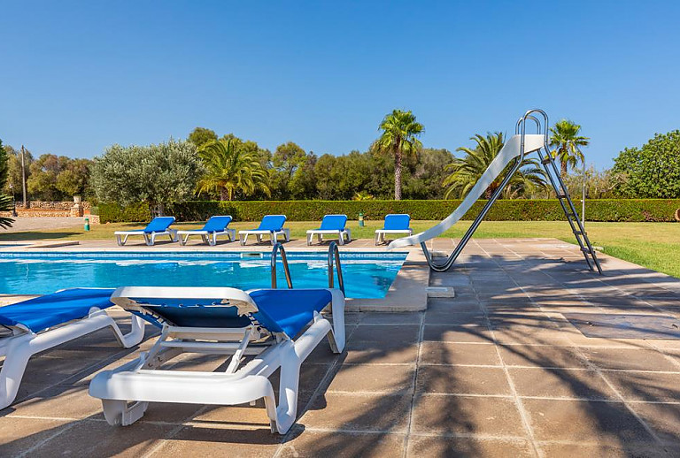 Poolliegen und Rutsche am Schwimmbecken