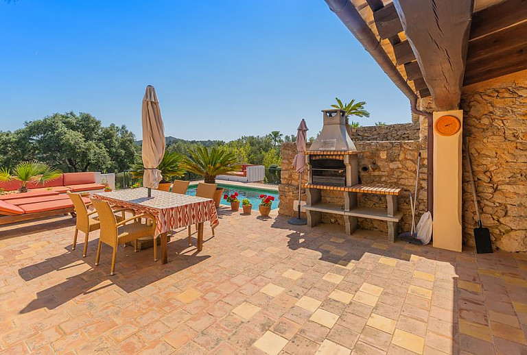 Terrasse mit Grill und Poolblick