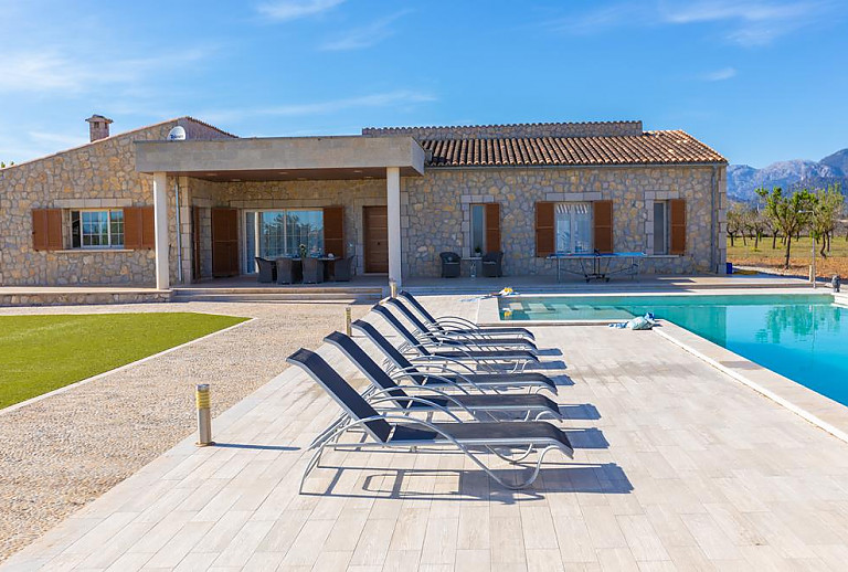 Sonnenliegen am Poolbereich vor dem Ferienhaus